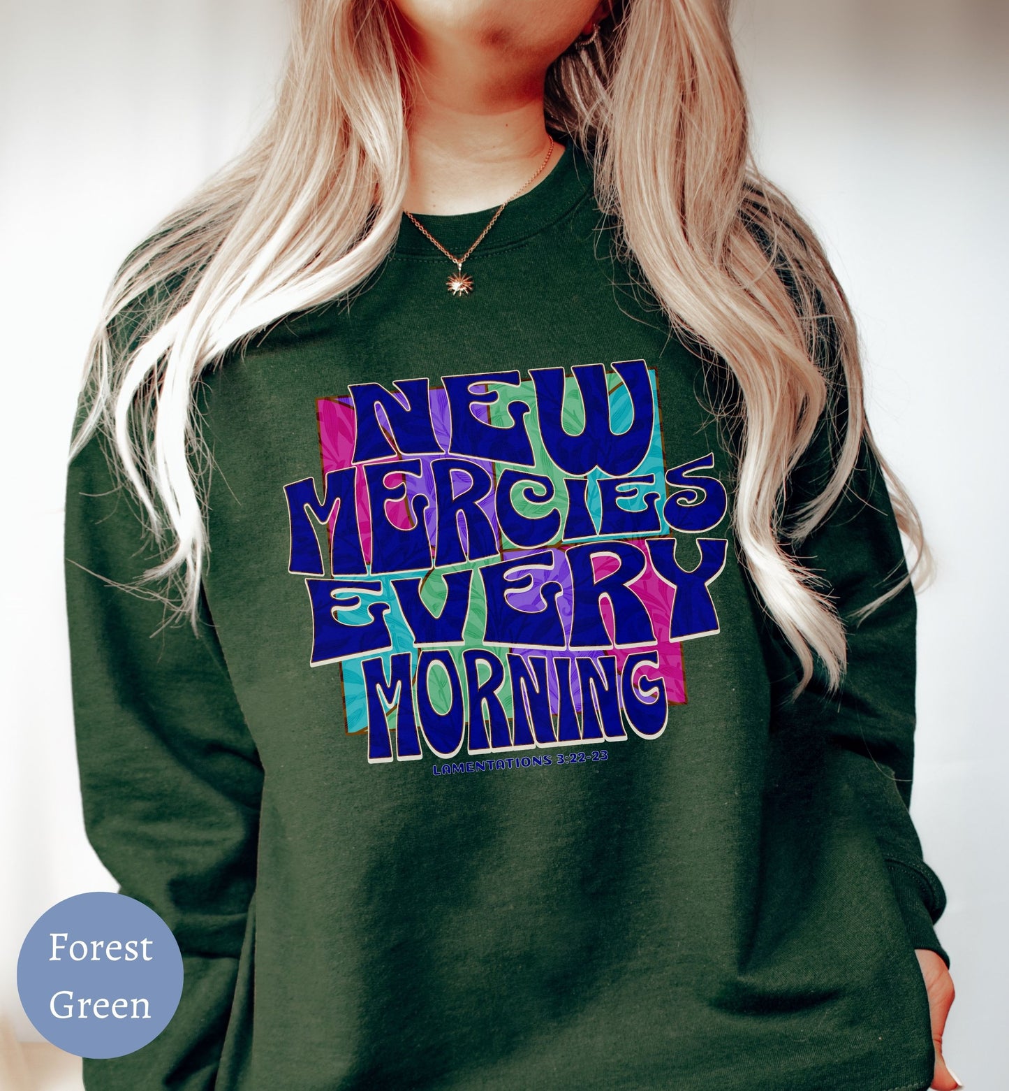 a woman wearing a green sweatshirt that says neu mercies every morning