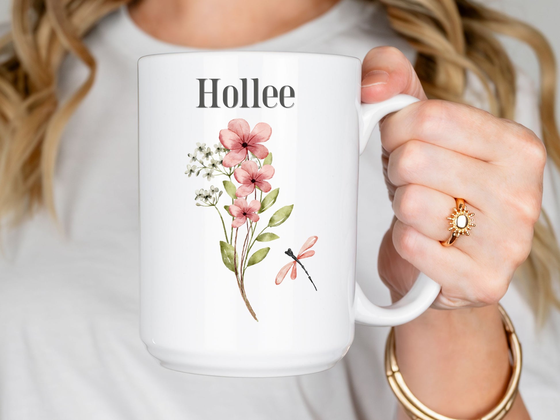 a woman holding a coffee mug with flowers on it