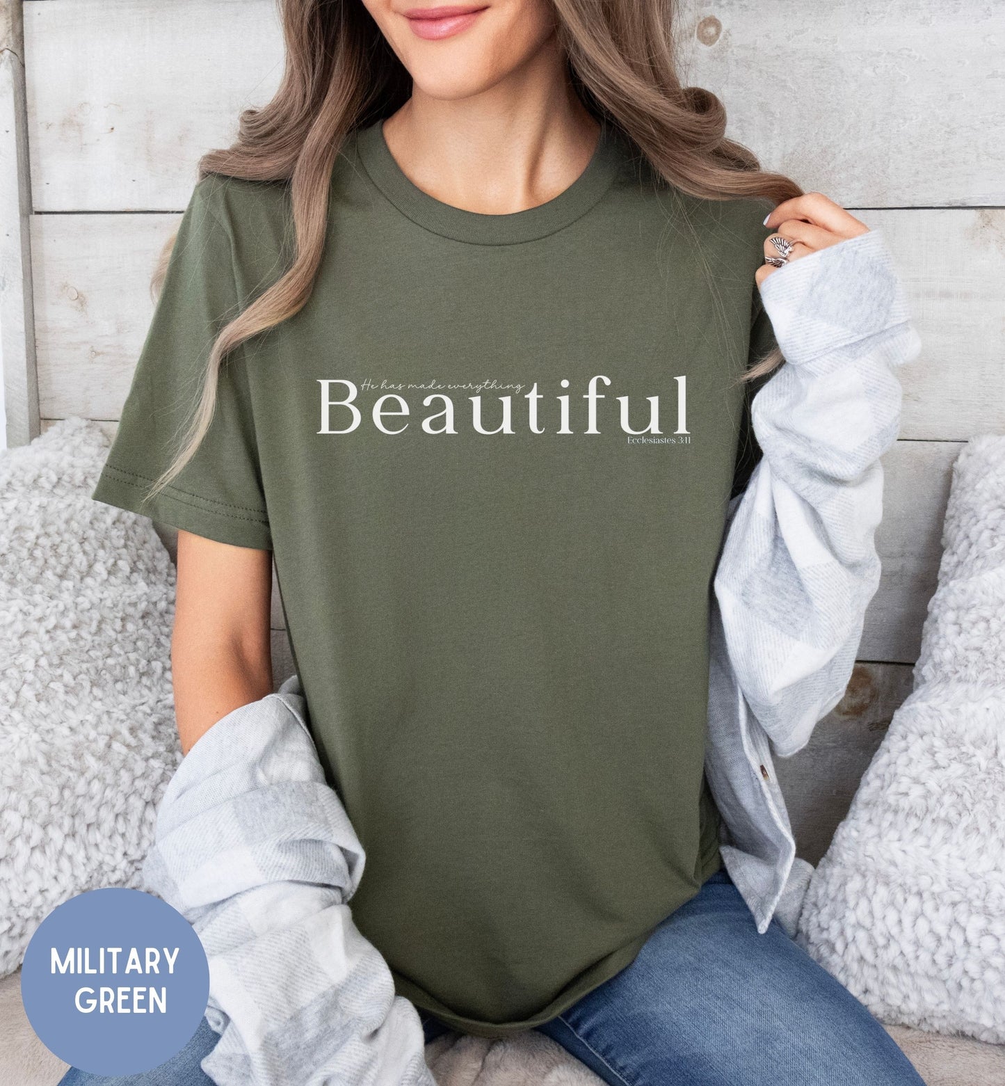 a woman sitting on a bed wearing a t - shirt that says beautiful