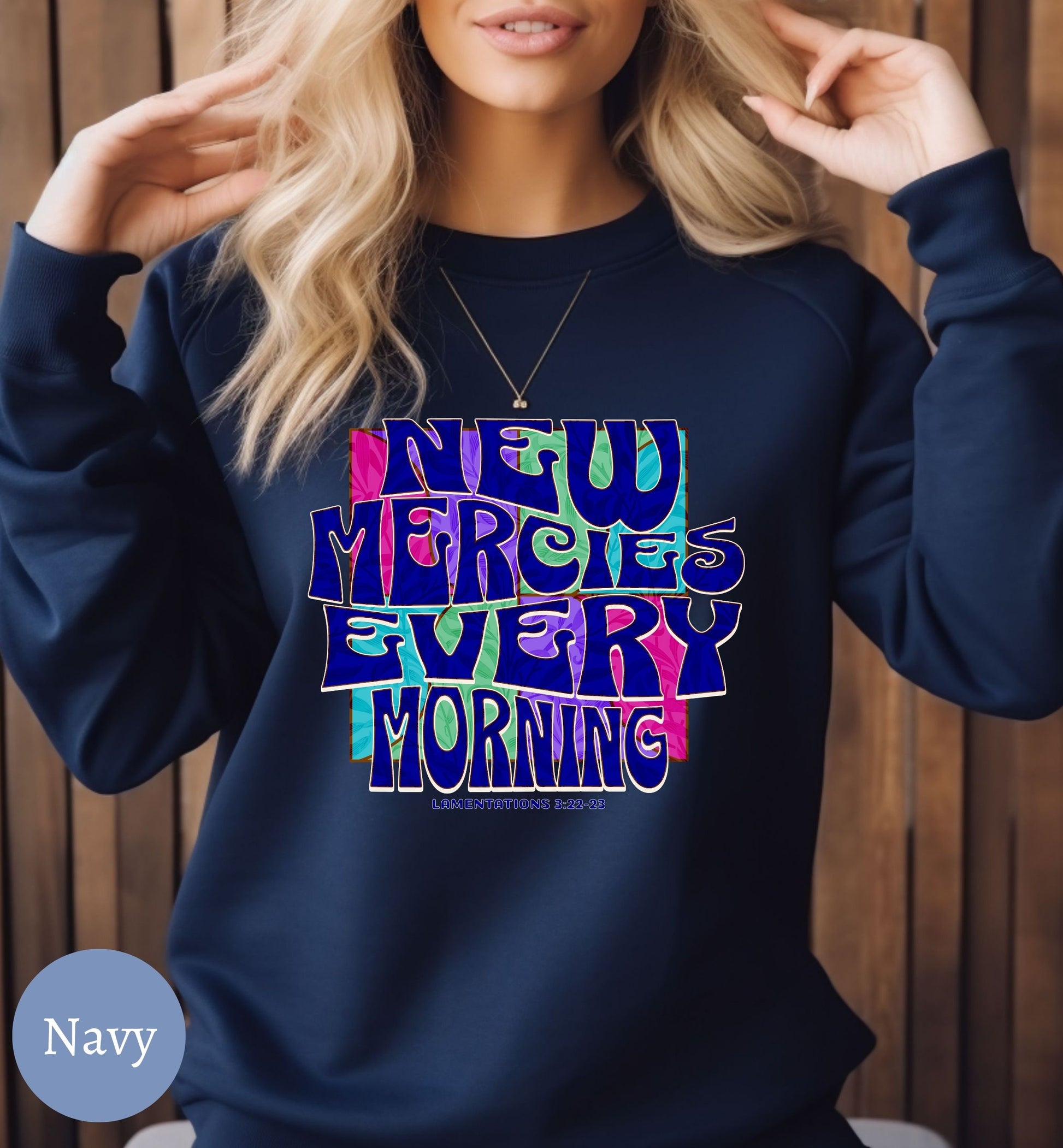 a woman wearing a sweatshirt that says new mercies every morning