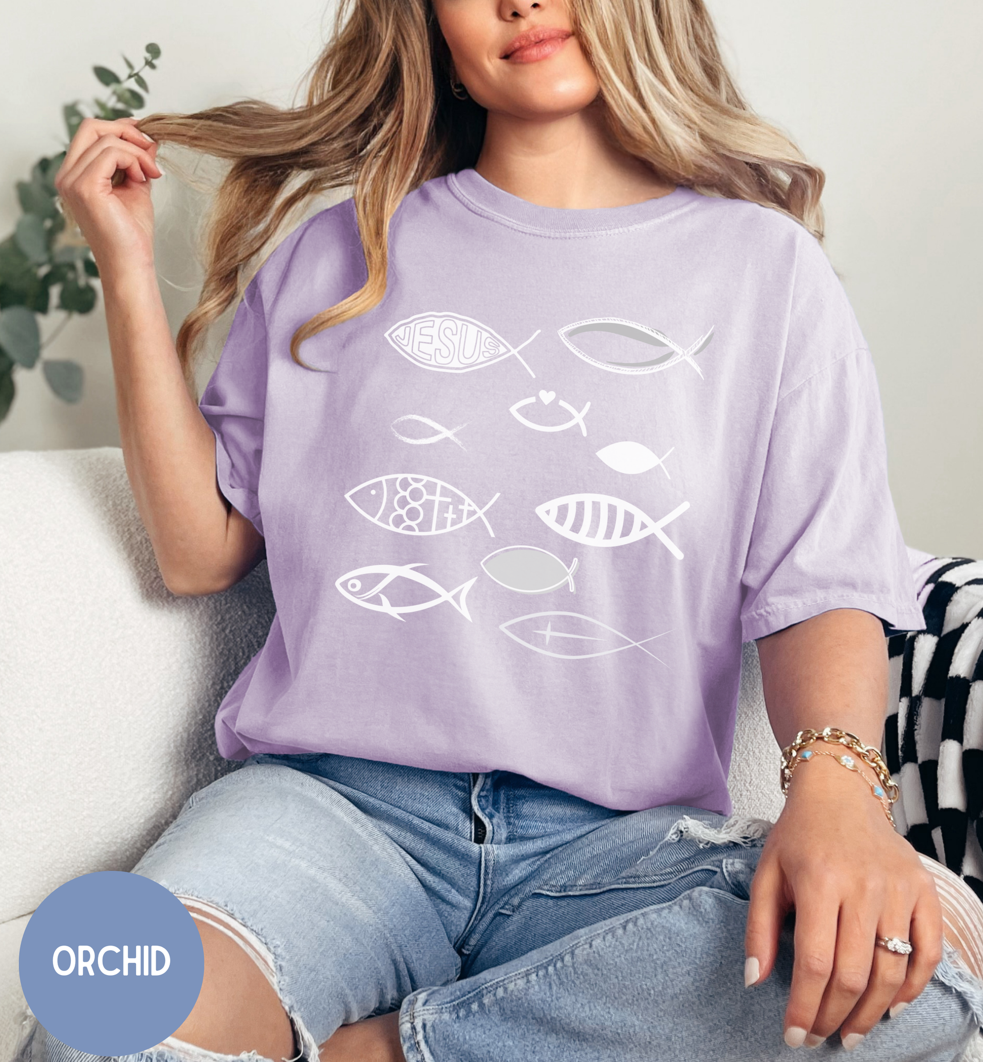 a woman sitting on a couch wearing a purple shirt with fish on it