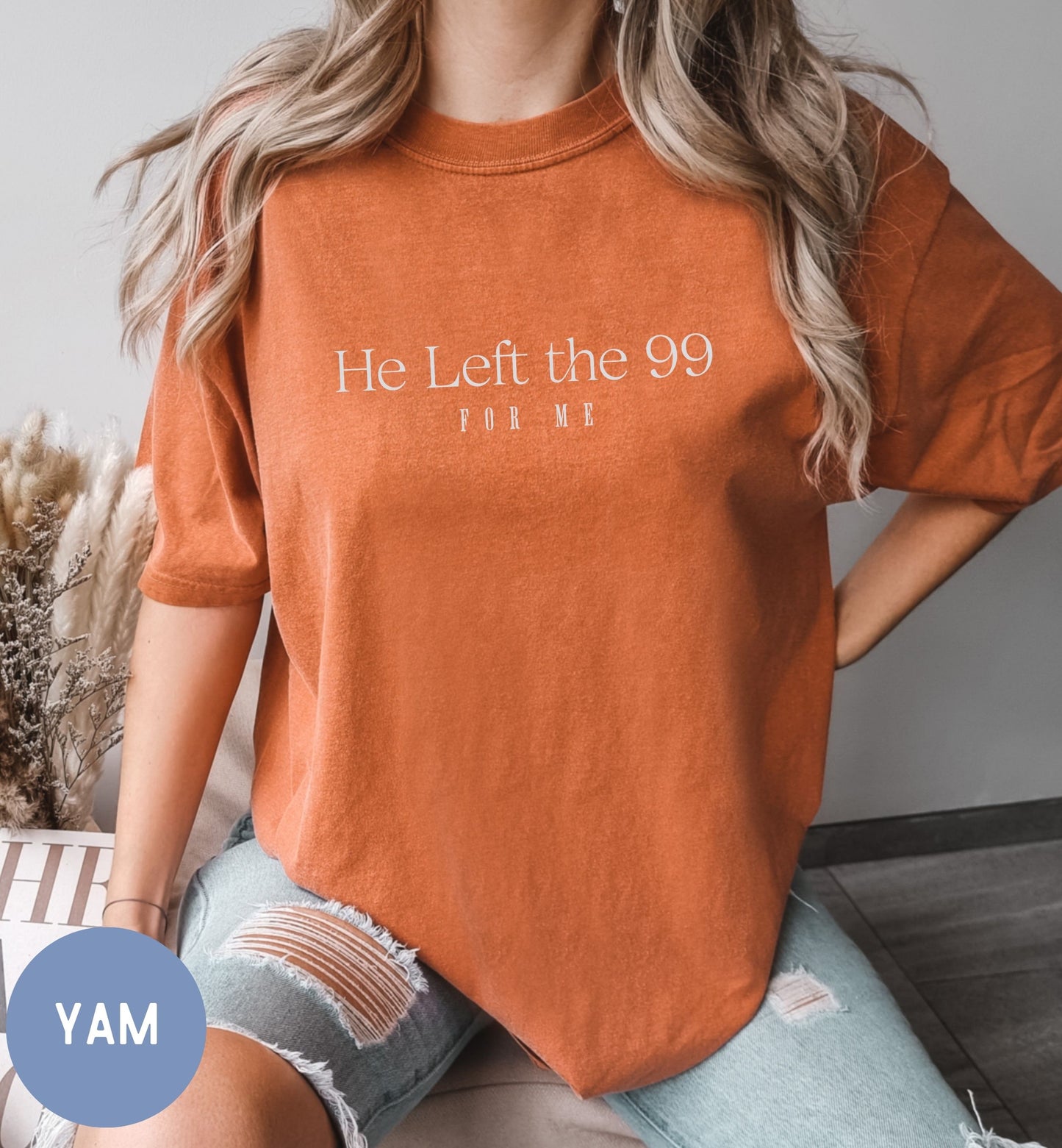 a woman sitting on a couch wearing a t - shirt that says he left the