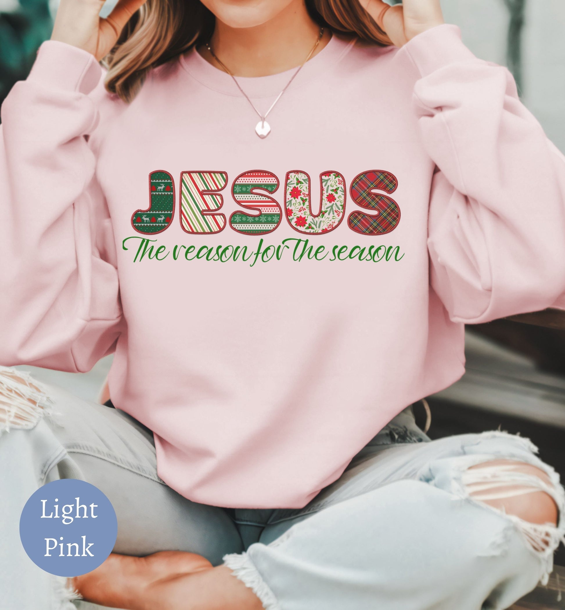 a woman wearing a pink sweatshirt that says jesus the reason for the season