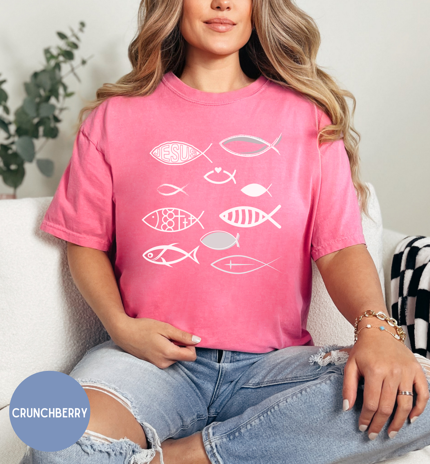 a woman sitting on a couch wearing a pink shirt with fish on it