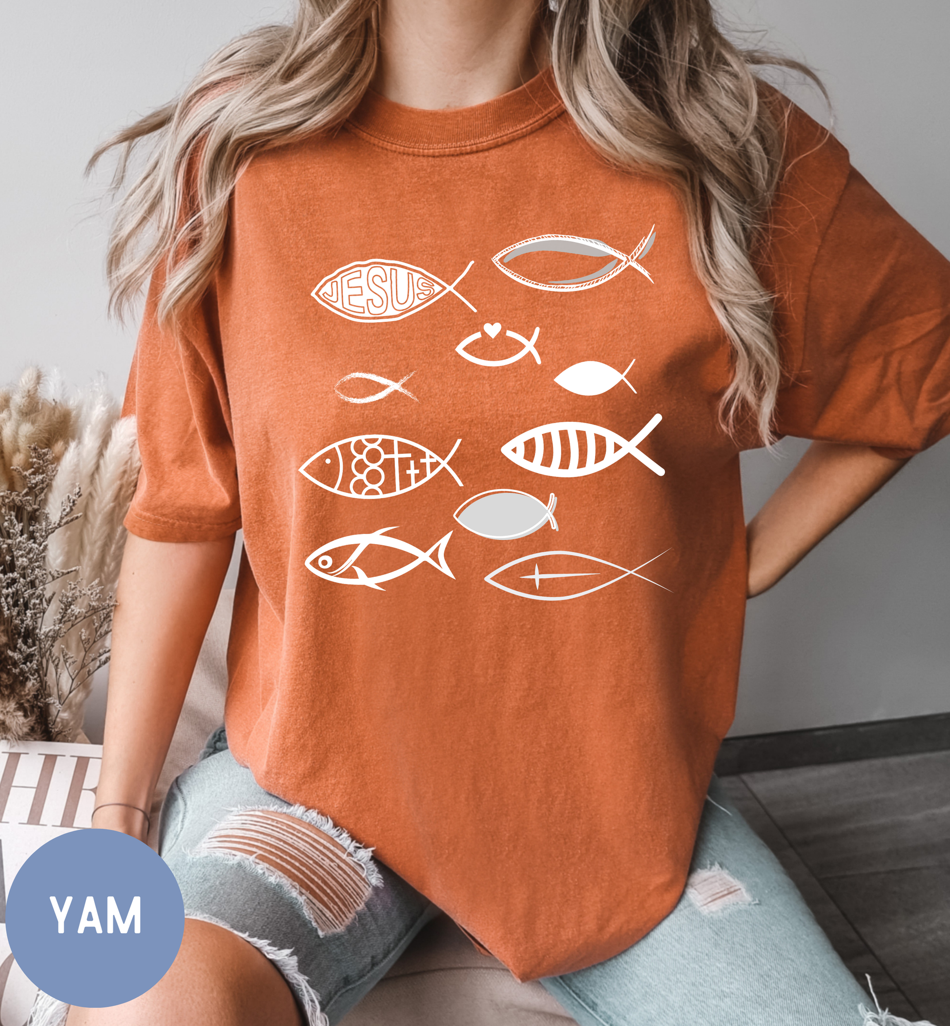 a woman wearing an orange shirt with fish on it