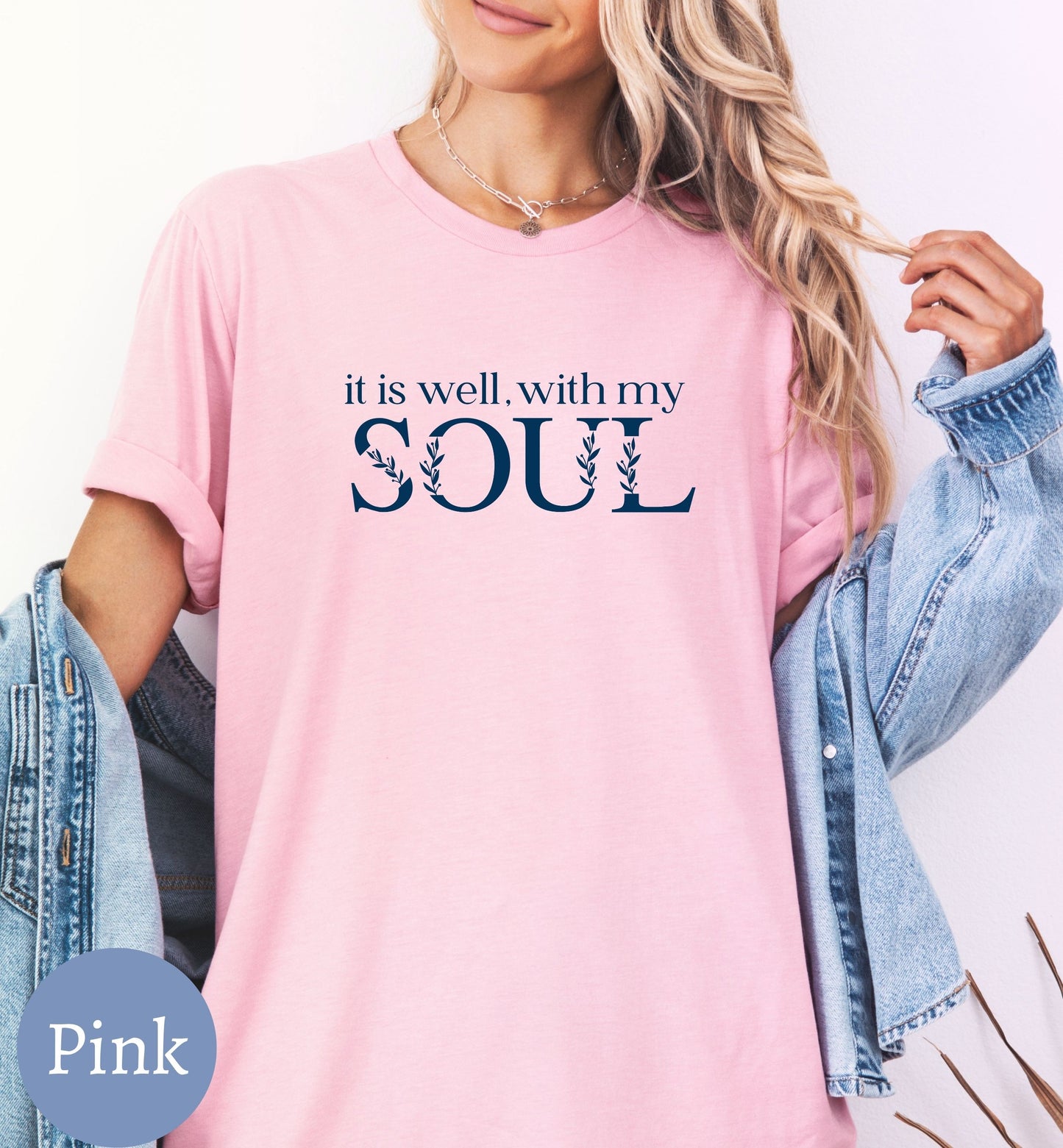 a woman wearing a pink shirt that says it is well with my soul