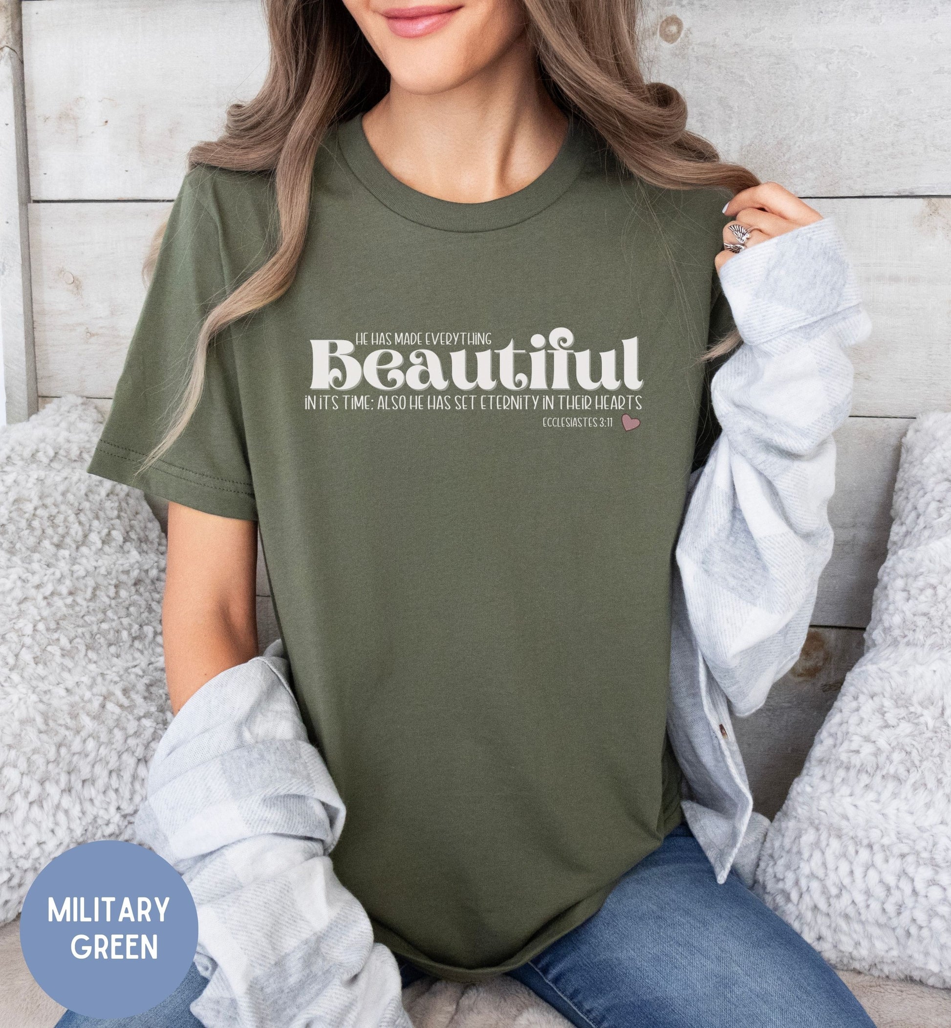 a woman sitting on a bed wearing a t - shirt that says beautiful