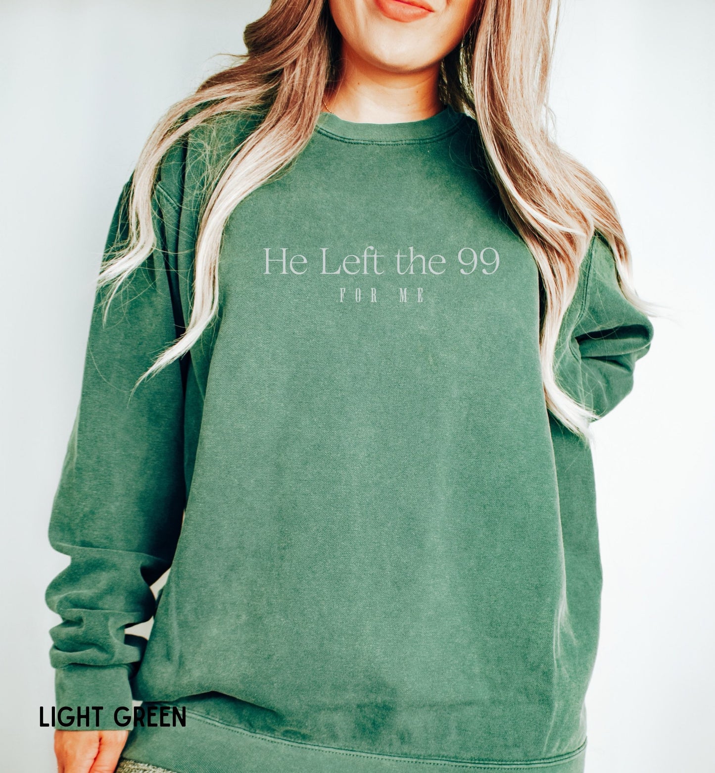 a woman wearing a green sweatshirt with the words he left the 99 on it