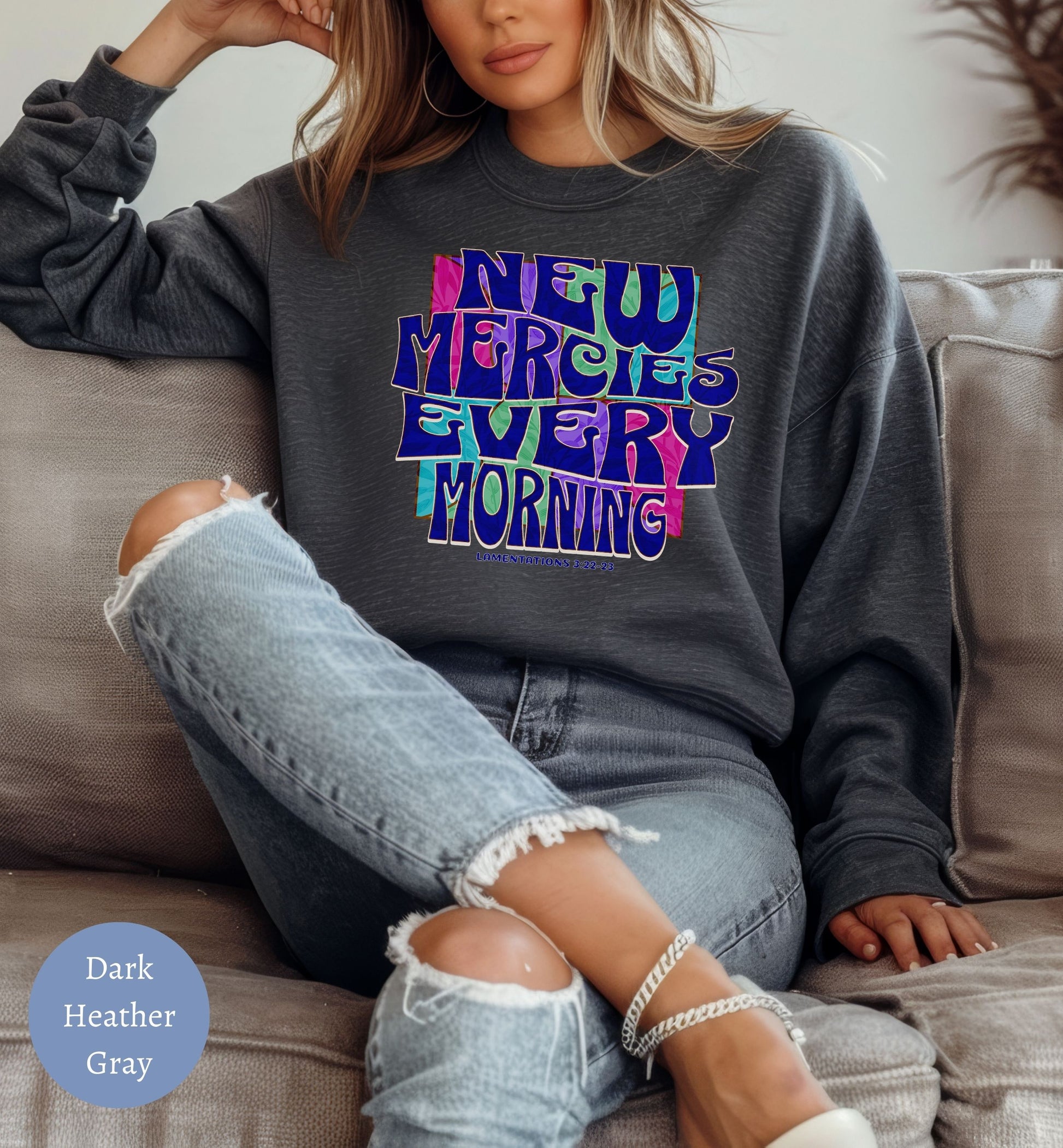 a woman sitting on a couch wearing a sweatshirt