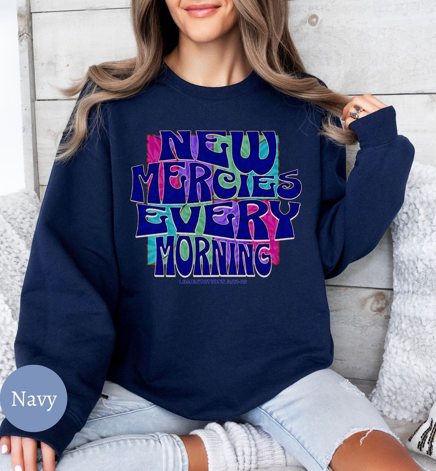 a woman sitting on a couch wearing a navy sweatshirt